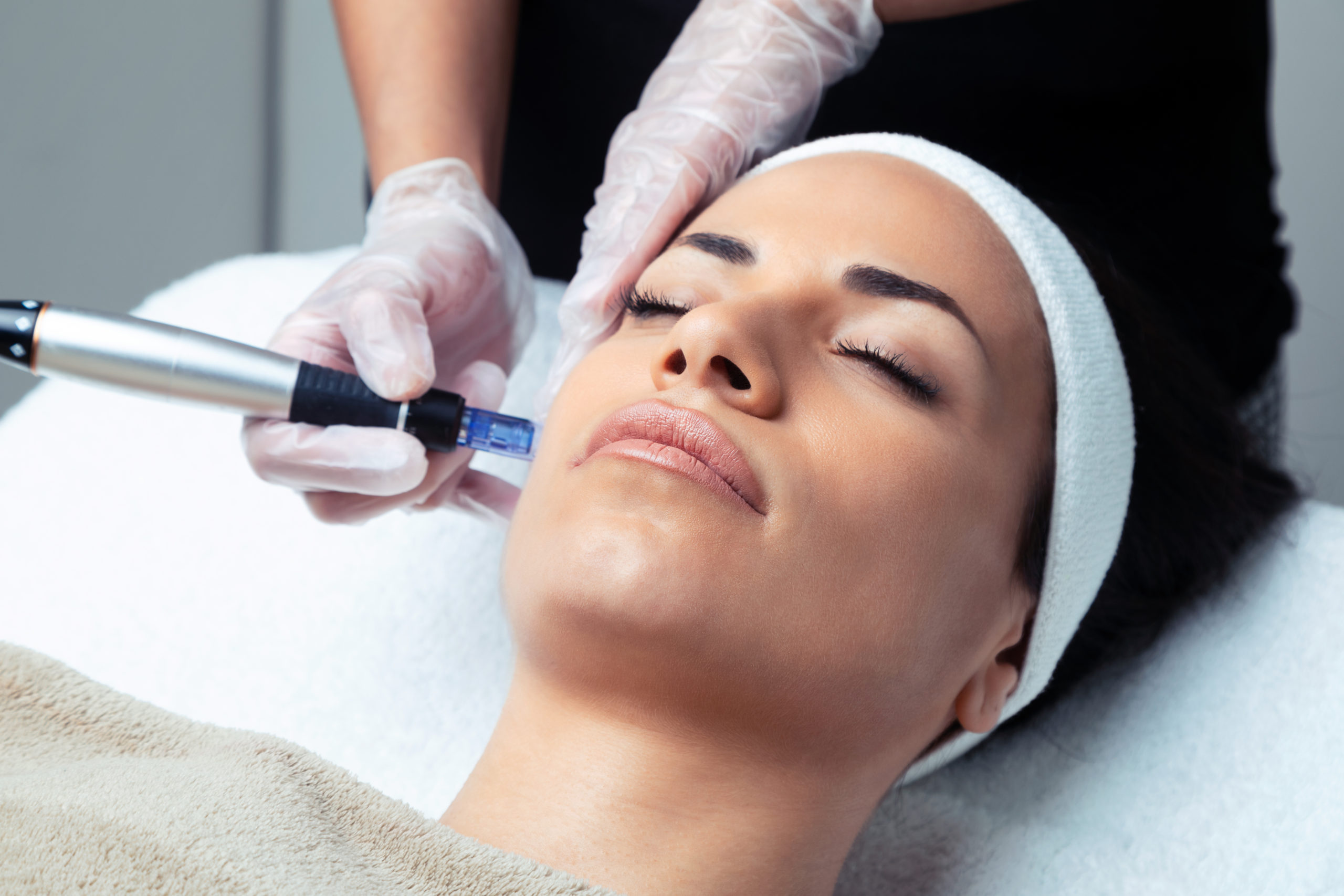 Cosmetologist making mesotherapy injection with dermapen on face