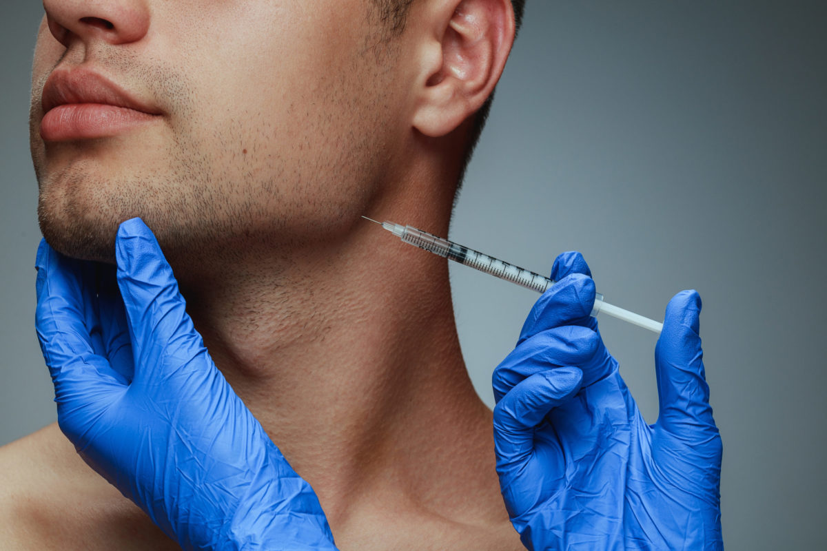 Close-up portrait of young man isolated on grey studio background